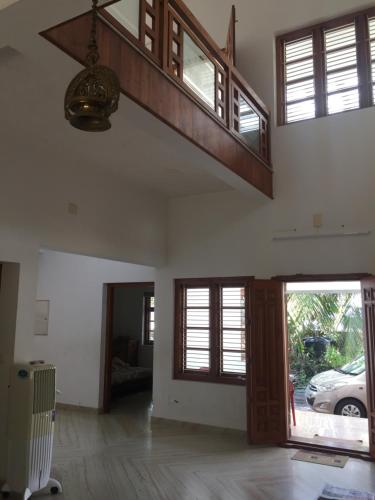 an empty room with a staircase and a living room at Kannur Beachdrive Homestay in Thottada