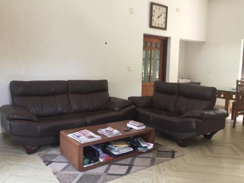 a living room with two couches and a coffee table at Kannur Beachdrive Homestay in Thottada