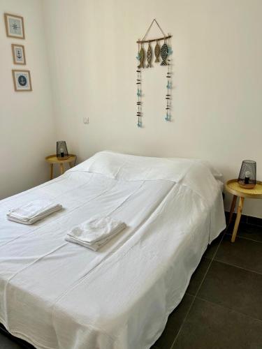 - un lit blanc avec des draps blancs et des serviettes dans l'établissement Charmante maison vue garrigue avec piscine, à Lapalme