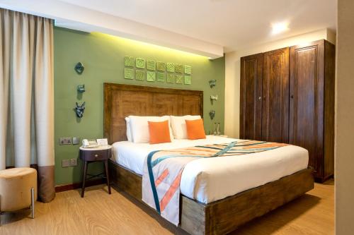 a bedroom with a large bed with orange pillows at Kabira Country Club in Kampala