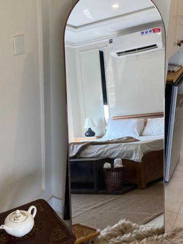 a mirror in front of a bed in a room at Bohemian Studio Apt Bahria town Lahore in Rāmkot