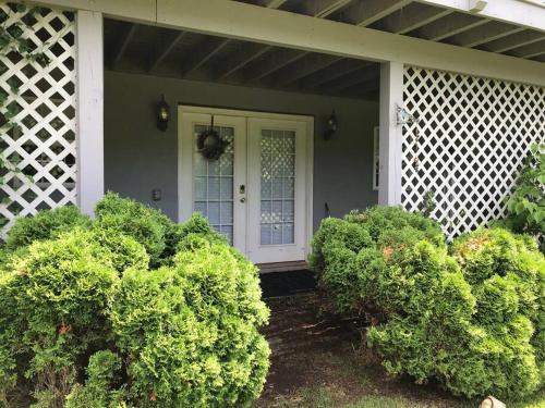 a house with green bushes in front of a white door at Three Springs Plus in Lovingston