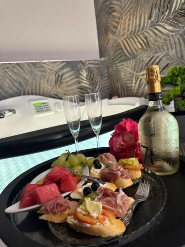 a table with a plate of food and two wine glasses at Aquada Experience in Francavilla al Mare