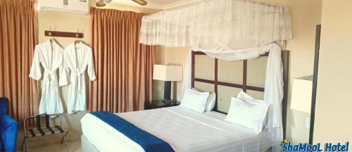 a bedroom with a bed with a canopy at ShaMooL Hotel in Dar es Salaam