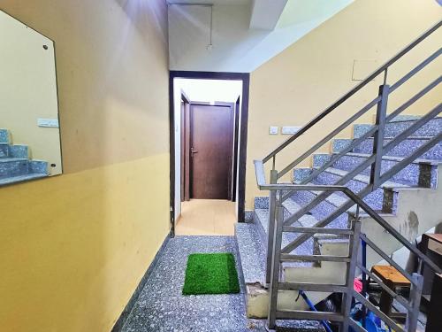 a hallway with stairs and a door with a green rug at Rest Inn Hotel Newtown Road Near Tata Medical in Kolkata