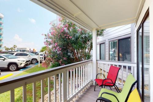 a porch with two chairs and a view of a parking lot at Plantation West Condos in Gulf Highlands
