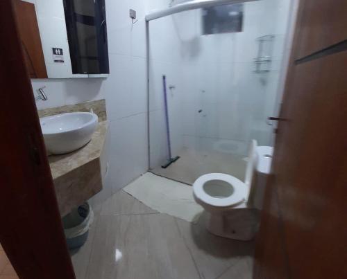 une salle de bain avec des toilettes blanches et un lavabo dans l'établissement Casa de férias luar do prado, à Prado