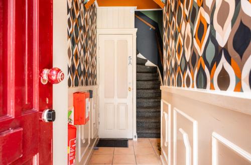a hallway with a red door and colorful wall at The Disco Duck B - city centre Zwolle in Zwolle