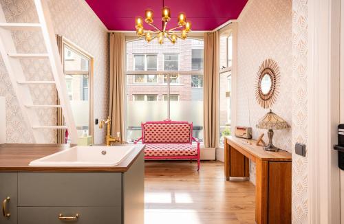 a bathroom with a sink and a pink chair at The Disco Duck B - city centre Zwolle in Zwolle