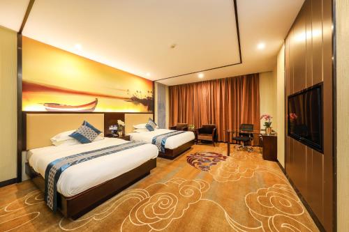 a hotel room with two beds and a television at Bosheng International Hotel Guangzhou Baiyun International Airport Huadu Plaza Branch - Free Deliver Service to Guangzhou Baiyun International Airport & Free Deliver Service to Canton Fair Complex During Canton Fair Period in Huadu