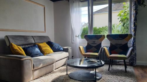 a living room with a couch and two chairs at La maison ocre - chambre turquoise in Rezé