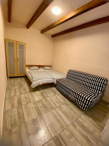 a room with two beds and a couch in it at Tieffapartmanház Zamardi in Zamárdi