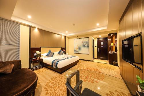 a hotel room with a bed and a television at Bosheng International Hotel Guangzhou Baiyun International Airport Huadu Plaza Branch - Free Deliver Service to Guangzhou Baiyun International Airport & Free Deliver Service to Canton Fair Complex During Canton Fair Period in Huadu
