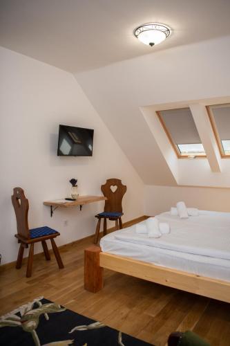 a bedroom with a bed and two chairs at Tokaji Dűlő Vendégház in Tokaj