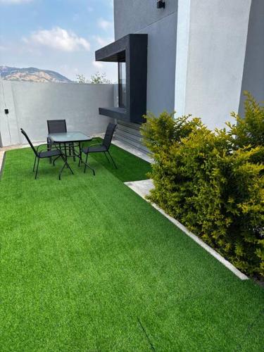 a patio with a table and chairs on the grass at iThusi in Mbabane