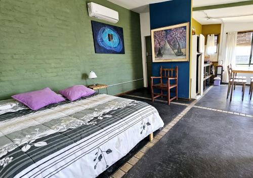 a bedroom with a large bed with purple pillows at El Atelier - Valle de Uco in La Consulta