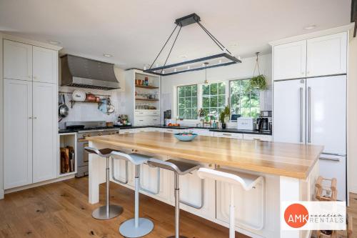 a kitchen with white cabinets and a wooden counter top at Beautiful Custom Lake House in Holland
