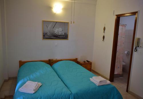 a small bedroom with a blue bed in a room at Aegina Town Cozy Escape in Aegina Town