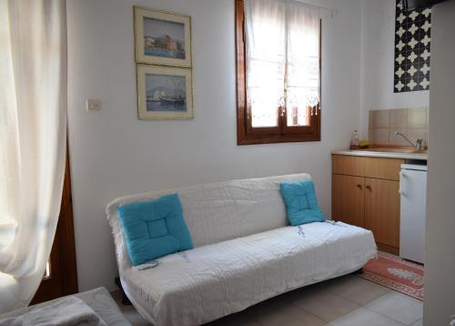 a living room with a couch with blue pillows on it at Aegina Town Cozy Escape in Aegina Town