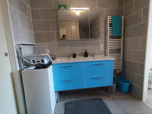une salle de bain avec un lavabo bleu et un miroir dans l'établissement Appart complet 3 chambres calme facture et repas possibles, à Beausemblant