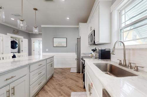 a kitchen with white cabinets and a sink at Carried Away by Meyer Vacation Rentals in Gulf Shores
