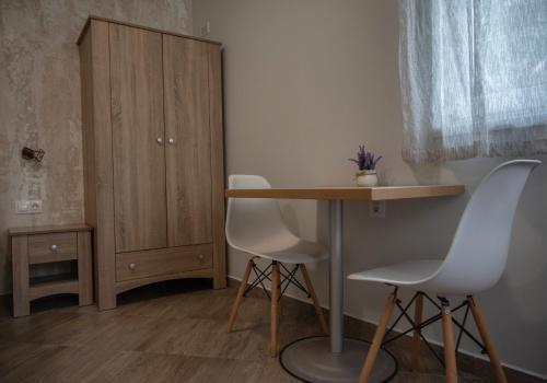 a room with a table and two chairs and a cabinet at Къща за гости Фолис in Kyustendil