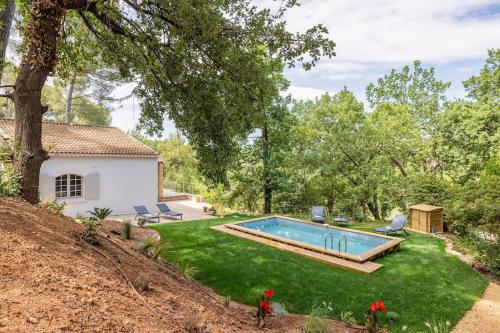 une cour avec une piscine et une maison dans l'établissement Villa La Pinède, à Aix-en-Provence