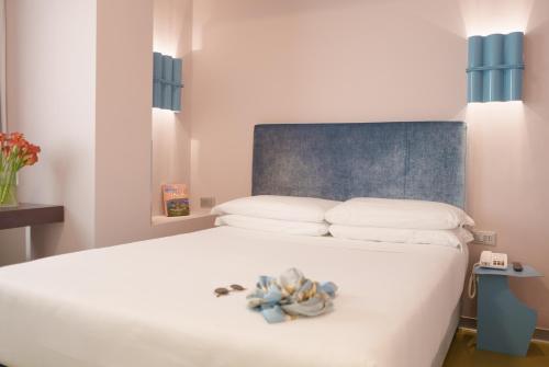 a white bed with a teddy bear sitting on it at Moderno Hotel Roma in Rome