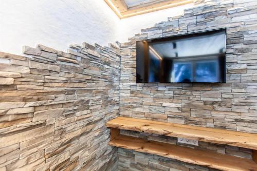 a stone wall with a flat screen tv on a wall at Casa de Wisa in Gaschurn