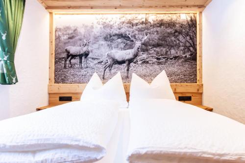 a bedroom with two deer in a picture on the wall at Casa de Wisa in Gaschurn