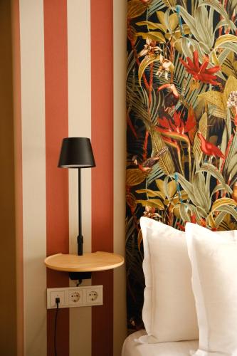 a room with a bed and a table with a lamp at Margot Sololaki in Tbilisi City