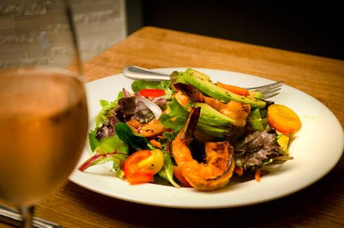 a plate of salad with shrimp and a glass of wine at Barrows House in Dorset