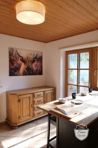 a kitchen with a table with a bull painting on the wall at FeWo Schönwetter in Weßling