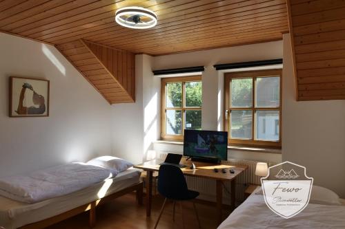 a room with two beds and a desk with a computer at FeWo Schönwetter in Weßling