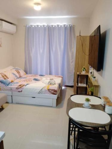 a bedroom with a bed and two chairs and a table at Saekyung Condominium in Basbas