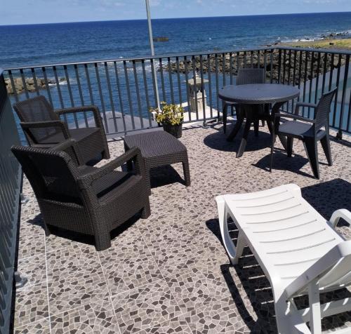 a patio with chairs and a table and the ocean at Casa dos avós in São Vicente