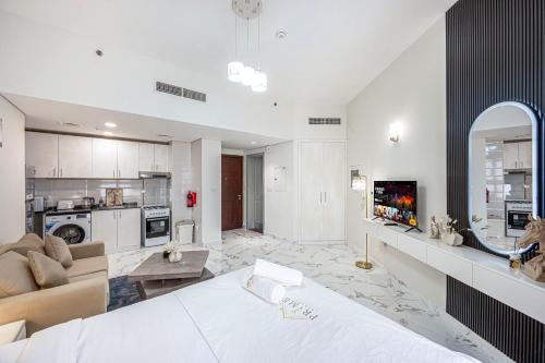 a large living room with a couch and a kitchen at Comfortable Studio With Dubailand Vibes in Dubai