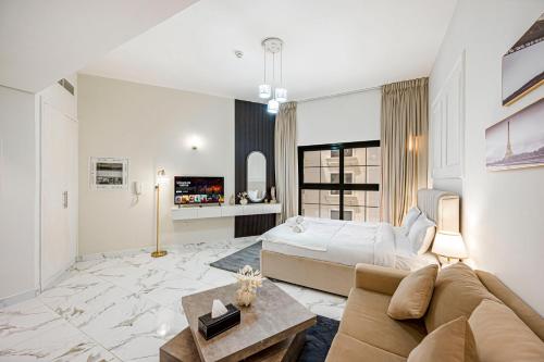 a large bedroom with a bed and a couch at Comfortable Studio with Dubailand Vibes in Dubai