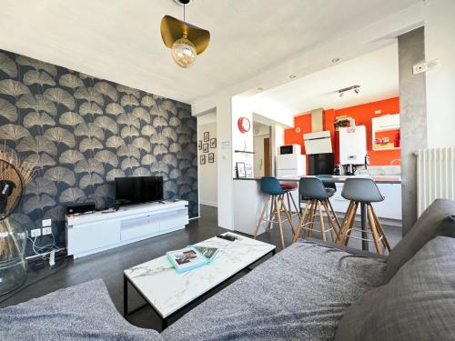 un salon avec un canapé et une cuisine dans l'établissement F3 Centre- Ville Lafayette avec garage, à Clermont-Ferrand