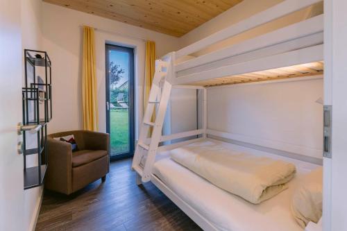 ホーヴァハトにあるHaus Strandlustの二段ベッド2台と椅子のある寝室