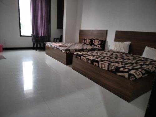 two beds sitting in a room with at Ashirwad Hotel in Rīngas