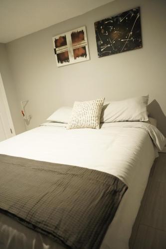 a bed in a bedroom with two pictures on the wall at Cozy 2 Bedroom In A Lovely Forest Hills Neighborhood in Parkside