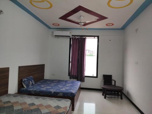 a bedroom with a bed and a table and a window at Ashirwad Hotel in Rīngas