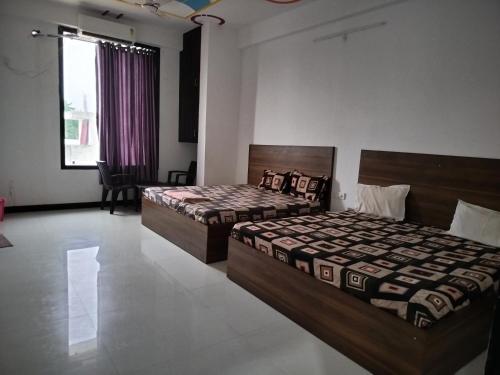 two beds in a room with a room with at Ashirwad Hotel in Rīngas
