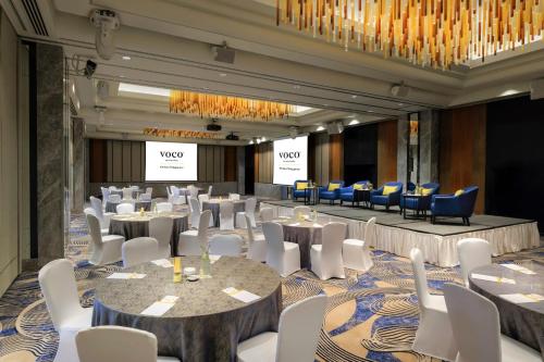 a conference room with tables and chairs and a chandelier at voco Orchard Singapore by IHG in Singapore