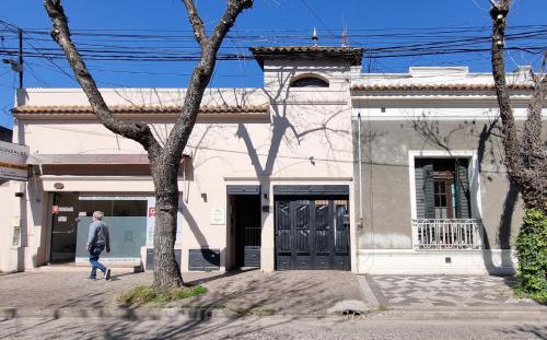 a man walking in front of a building at NidoAparte III Lujan Centro-4 Pax-Duplex in Luján
