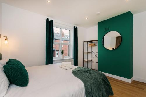 a bedroom with a large bed with a green accent wall at Contractors,Parking,Wifi, SmartTV in Heeley