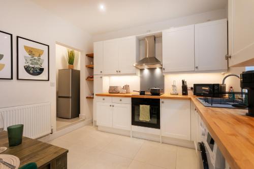 a kitchen with white cabinets and a stainless steel refrigerator at Contractors,Parking,Wifi, SmartTV in Heeley