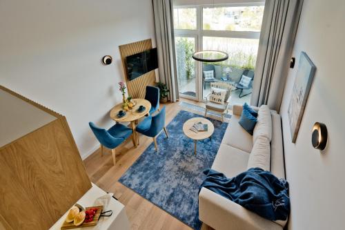 a living room with a couch and a table at Aparthotel Anchoria BlueApart in Mechelinki
