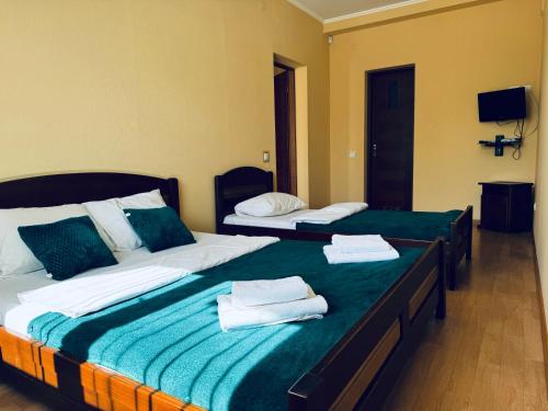 two beds in a room with towels on them at Etna Hotel in Lviv